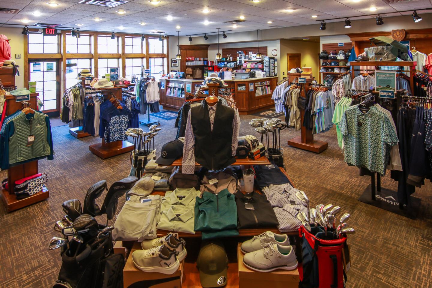 Golf pro shop with clothing, accessories, and equipment displays.