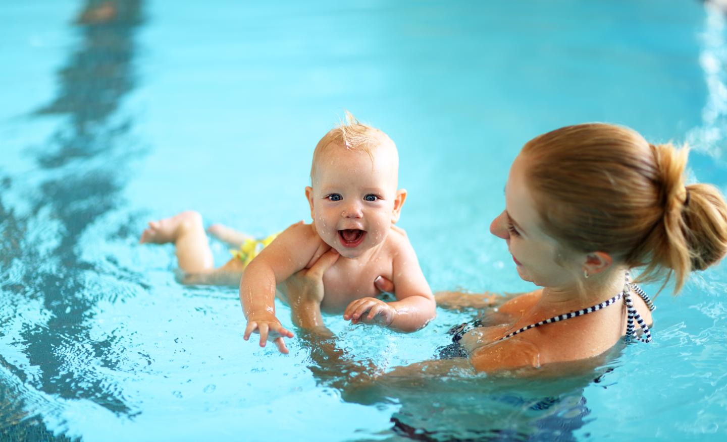 Parent and baby swim in pool during Parent and Me Lesson.