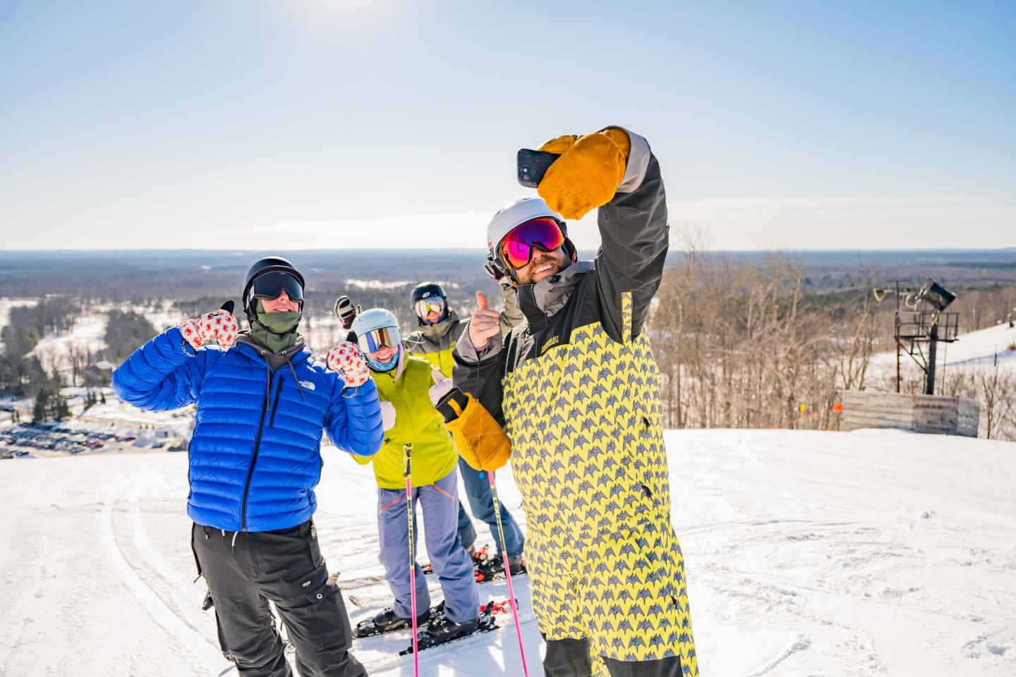 Skiers taking a selfie on a sunny snowy slope.