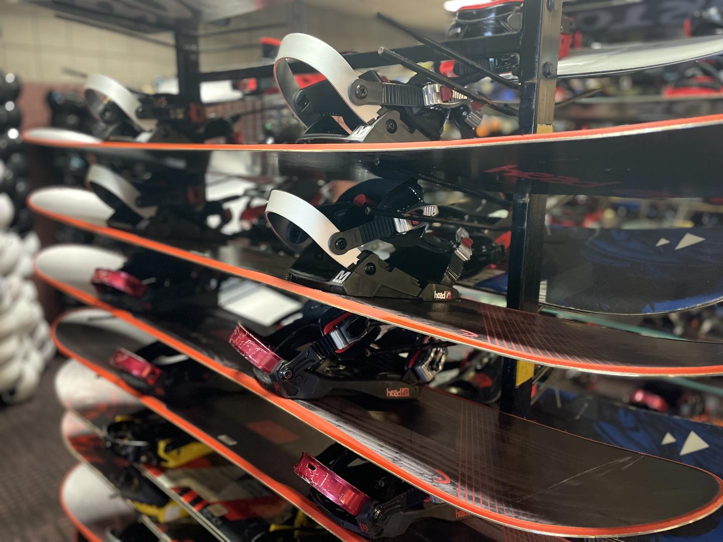Snowboards stacked on a rack in a store.