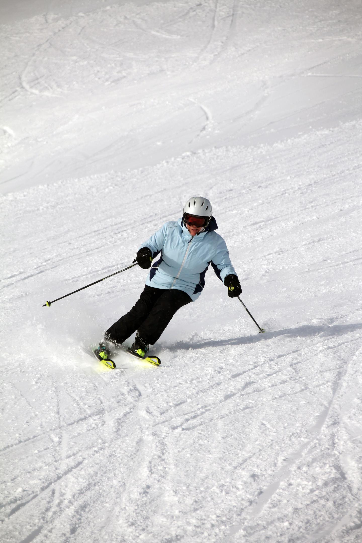 Person skiing downhill on a snowy slope.