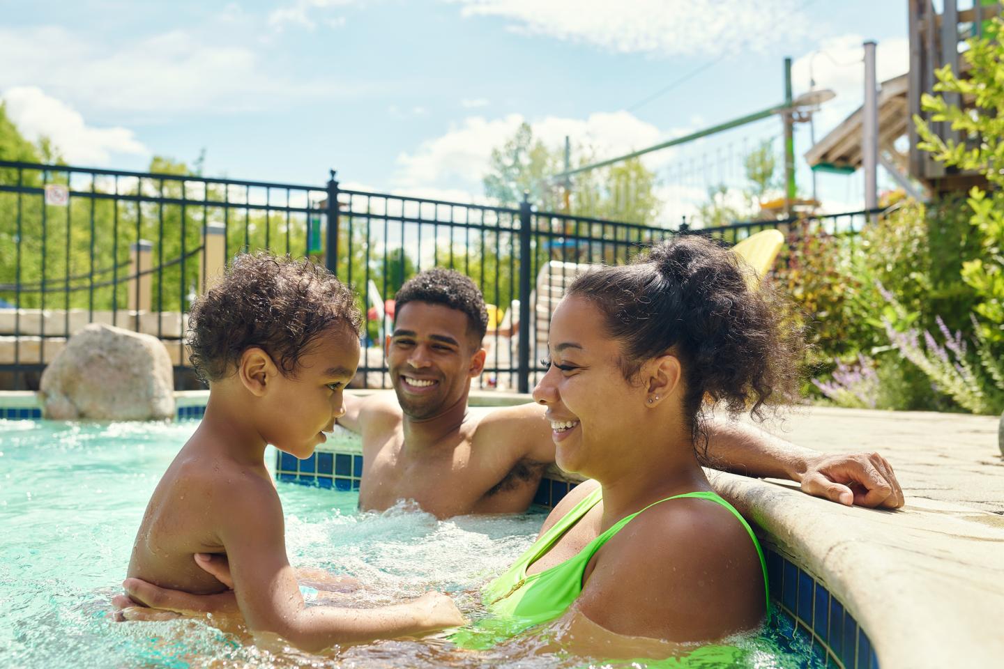A family enjoying a sunny day in a swimming pool.