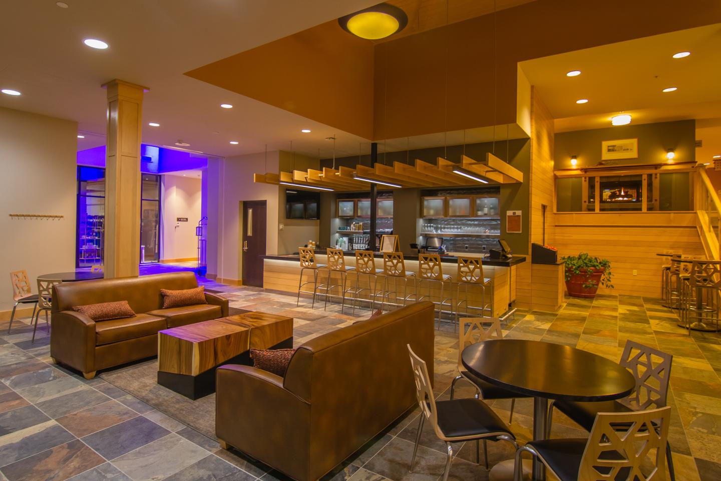 Hotel lobby with seating, a bar area, and warm lighting.