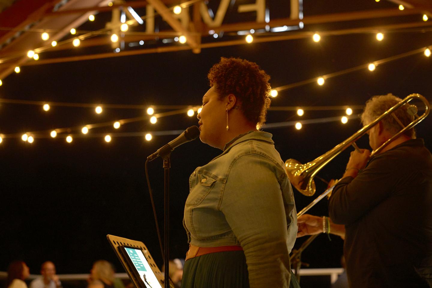 Singers performing under string lights at an evening at Level4 Lounge.