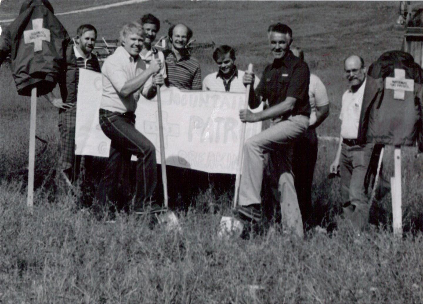 A group of men standing in a field holding shovels on the groundbreaking of the Ski Patrol building.