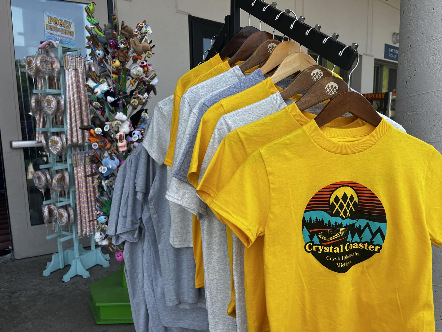 Yellow and gray T-shirts on a rack outside a shop.