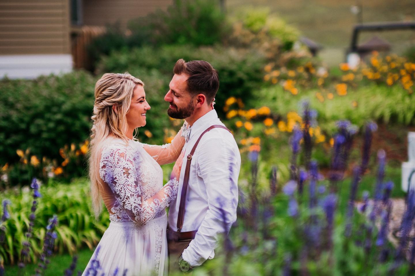 Bride and groom embrace in a vibrant flower garden.