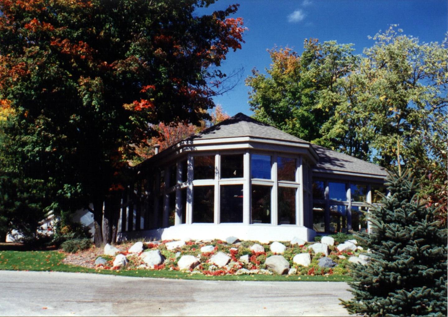 The Peak surrounded by colorful trees and a clear blue sky.